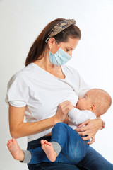 Breastfeeding mother wearing a mask on white background