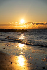 Sunrise over Atlantic Ocean with a red sky and red sunbeams and blue ocean water. 