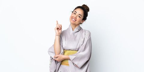 Woman wearing kimono over isolated background pointing up a great idea