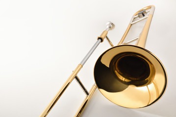 View of the bell of a trombone on a white table - obrazy, fototapety, plakaty