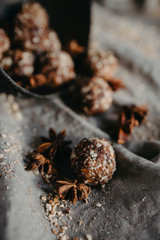 Homemade healthy vegan chocolate truffles with dates, coconut flakes and rolled oats served on silver tray