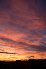 Sunset. Evening sky, clouds are painted in different bright colors: blue, red, orange, purple, pink, yellow.