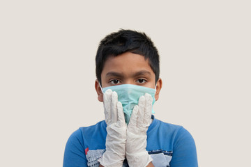 Boy wearing rubber glove putting on protective mask
