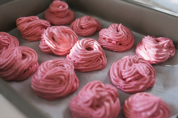 the little pen of a child wants to eat pink marshmallows, touches a finger. Home-cooked sweets, delicious food. sunny modern kitchen. Good mood. Russian homemade marshmallow