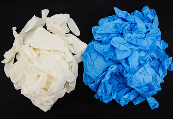 a lot of blue and white gloves on a black background. Medical concept. View from above. Hand protection.