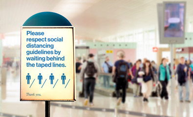 a sign inside an airport warns of the need to maintain the minimum safety distance between people to avoid contagion during the COVID-19 Coronavirus pandemic.