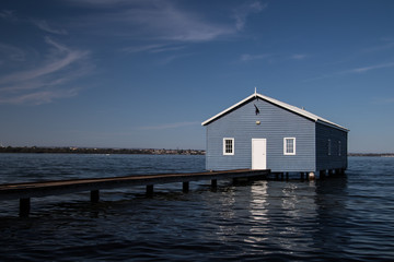 Peculiar house sitting over the water on clear summer day