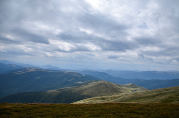 Landscape of Carpathian mountain range. Clouds over green mountain hills. Beauty of nature. Svydovets ridge. Ukraine