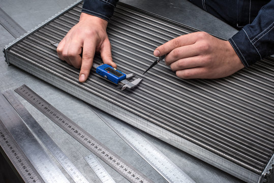 Checking car cooling radiator with calliper, quality control