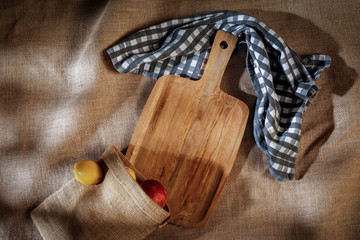 Tablecloth on a wooden table in the light of the morning sun with free space for an advertising product