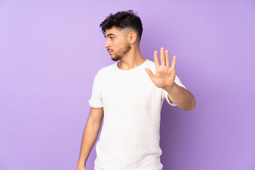 Arabian handsome man over isolated background making stop gesture and disappointed