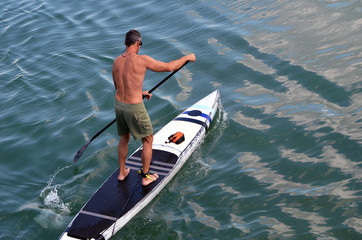 Obraz premium Man paddling on a paddle board