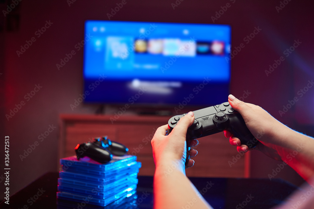 Wall mural gamer holding gamepad, controller or videogame joystick console in hands. close up, game concept