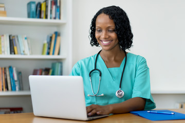 African american female doctor answering questions of patient online