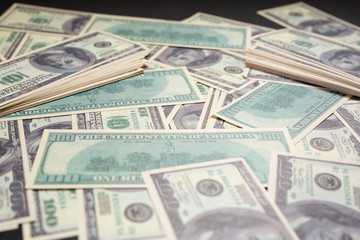 several dollar bills lying on a black background