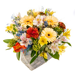 Bouquet of flowers in a braided high basket with greenery