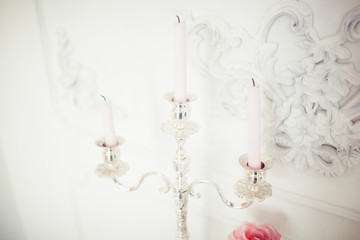 Many candles with candlesticks on the home background. Home and home decor.