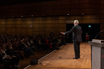 Mann auf der Bühne spricht vor Publikum