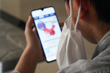 Wearing a mask of the boy see a mobile phone