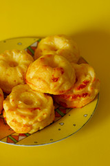 Fresh muffins on exquisite traditional plate on yellow backround, beautiful breakfast, tea time