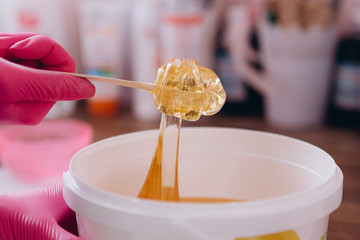 the process of epilation of parts of the female body by the method of shugaring, with the help of glucose paste which is glued to the skin and pulls out the hair with roots