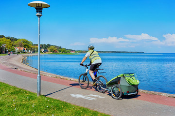 Man riding bicycle Nida resort Curonian Spit and Baltic Sea