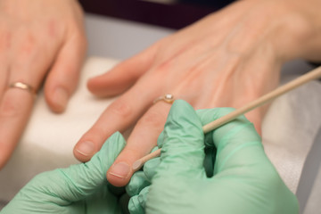 Woman hands in a nail salon receiving a manicure. Nail filing. Close up