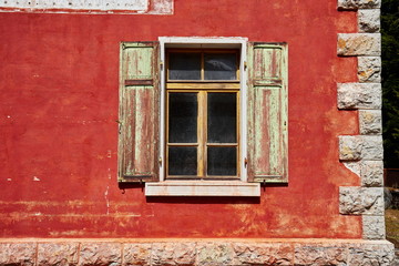 Fototapeta na wymiar Fenster mit Fensterladen an einer roten Fassade