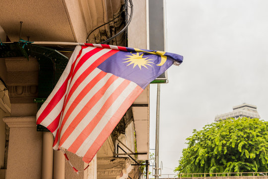 Old torn Malaysia flag in big city Kuala Lumpur, Malaysia.