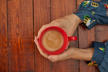 Mujer sujeta su taza de café con ambas manos.