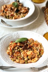 paella from orzo pasta with mussels, seashells and chicken. Seafood paella, traditional spanish dish. Paella on rustic black wooden table. Top view