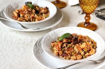 paella from orzo pasta with mussels, seashells and chicken. Seafood paella, traditional spanish dish. Paella on rustic black wooden table. Top view