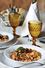 paella from orzo pasta with mussels, seashells and chicken. Seafood paella, traditional spanish dish. Paella on rustic black wooden table. Top view