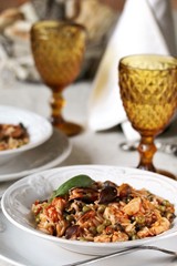 paella from orzo pasta with mussels, seashells and chicken. Seafood paella, traditional spanish dish. Paella on rustic black wooden table. Top view