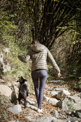 A young girl walk with her Labrador puppy in the forest.