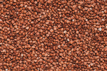 A closeup of buckwheat grains. Raw porridge top view. Grain pattern. Vegan raw food.