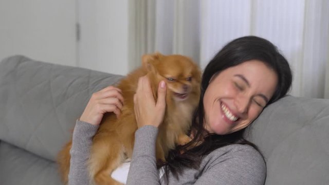 Woman use of mobile phone with her dog at home. Distancing concept
