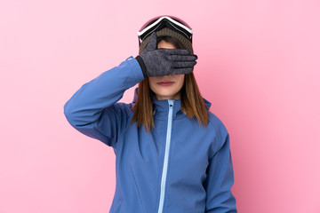 Young skier woman over isolated pink background covering eyes by hands