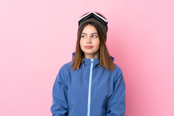 Young skier woman over isolated pink background standing and looking to the side