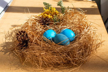 Painted Easter eggs in a nest of straw. Sunlight. Easter still life. - 336482729