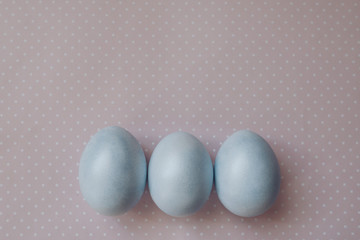 blue painted easter eggs on a pink background, pastel colors