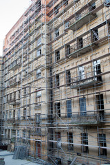 Fototapeta premium Tall building under construction with scaffolds. Scaffold. Construction Scaffoldings