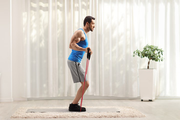 Man exercising with a resistance band at home