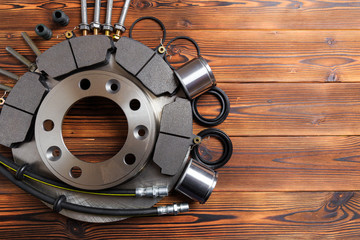 brake parts on wooden background  brake pads, disc, brake hose, guides, cylinders- Image