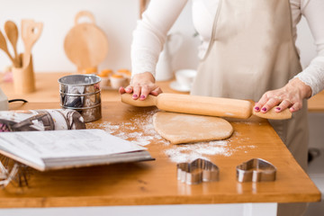 Woman's hands roll the dough. Protection Symbol, heat comfort.