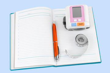 Open empty daily, pen, measuring tape, tonometer on blue background isolated. Top view. The concept of a healthy lifestyle, health diary. Copy space.