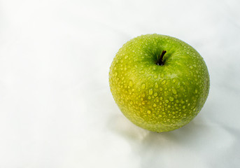 green apple wet with water drops on a white background