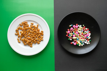 Many different weight loss pills and supplements as food on round white plate.