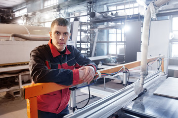Smiling Engineer worker on the background of an automated manufacturing furniture factory, modern production technologies