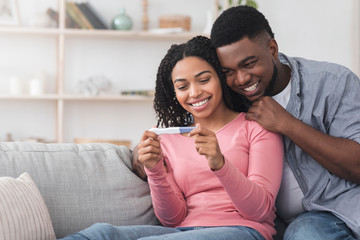 Obraz premium Married black couple happy with positive results of pregnancy test